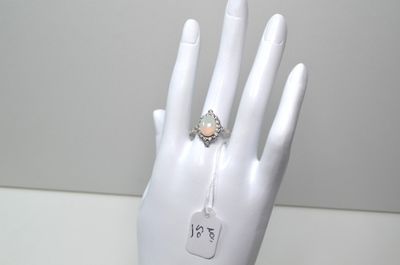 une bague sur la main d'un mannequin, à laquelle est accrochée une étiquette