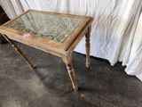 a small wooden table with a glass top on the floor
