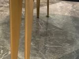 a black marble table with gold legs on a marble floor