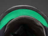 the bottom of a pair of black and green sneakers with a green sole