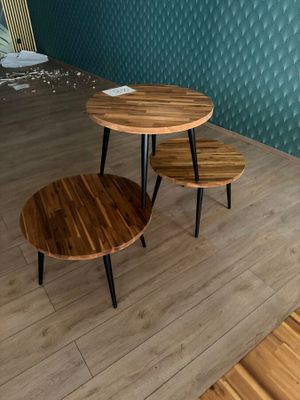 two tables that are sitting on a wooden floor