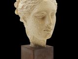 une image représentant une sculpture représentant une tête de femme posée sur un socle en bois
