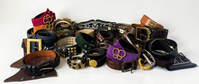 a lot of different types of belts on a white surface