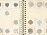 un livre ouvert sur lequel sont posées plusieurs pièces de monnaie différentes