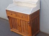 a wooden cabinet with a marble top on a sidewalk
