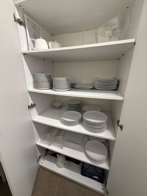 un cellier avec de nombreuses assiettes et bols sur les étagères