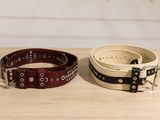 a pair of belts sitting on top of a wooden table