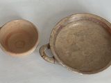 un bol marron et une tasse marron posés sur une table