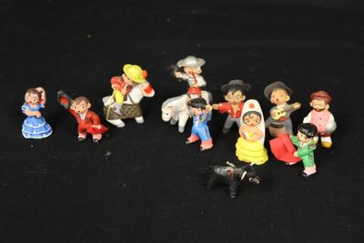 many figurines of different people on a black background
