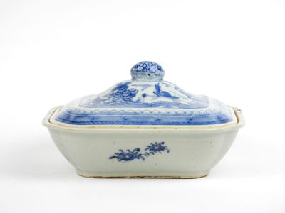a blue and white bowl with a lid on a white surface