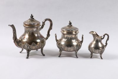 deux théières en argent et une cafetière posées sur une table