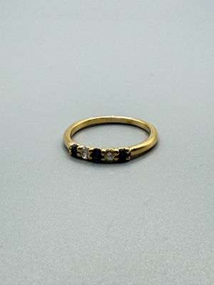 une image représentant une bague en or sertie de diamants noirs et blancs