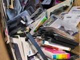 a cardboard box filled with lots of papers and pens