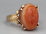 an image of a gold ring with a carved coral