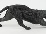 a figurine of a black cat running on a white surface