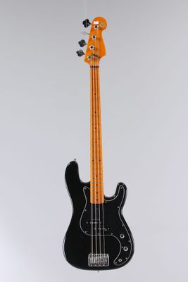 une guitare basse électrique suspendue à un fil fixé au mur