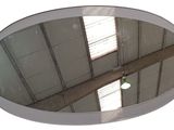 un miroir rond dans lequel se reflète un immeuble
