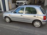 une voiture de couleur argentée garée devant un bâtiment
