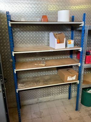 une étagère sur laquelle se trouvent quelques boîtes, dans une pièce