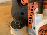 an orange and black chainsaw sitting on top of a wooden table