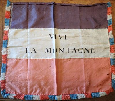 un gros plan sur un drapeau posé sur un parquet, sur lequel sont inscrits des mots