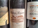 three bottles of red wine are lined up on a table