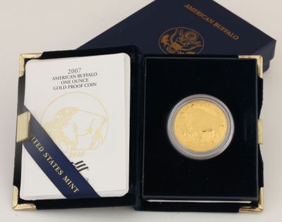 l'image d'une pièce d'or dans une boîte noire ornée d'un ruban bleu