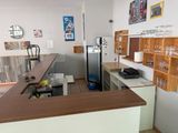 a kitchen with a refrigerator, sink, and shelves in it