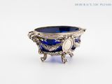 a silver bowl with a blue glass inside of it