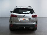 the rear end of a silver car in a white room