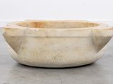 an image of a stone bowl sitting on top of a cement floor