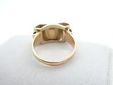 an image of a gold ring on a white surface
