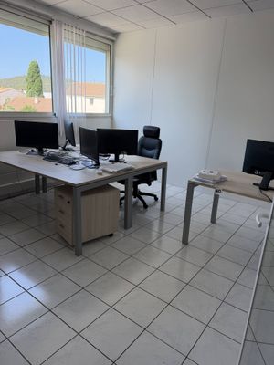 une photo d'un bureau avec deux écrans d'ordinateur et un bureau