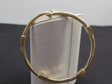 gros plan d'un bracelet en or sur une surface noire