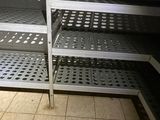 a metal shelf in the middle of a kitchen