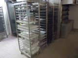 de nombreux plateaux de nourriture posés sur une étagère métallique dans une cuisine