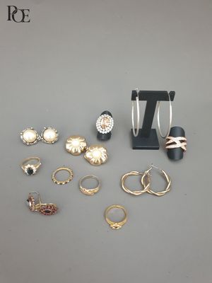 beaucoup de bagues et de boucles d'oreilles posées sur une table