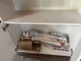 une armoire blanche contenant tout un tas d'objets