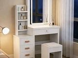 une coiffeuse blanche avec un miroir et un tabouret, placée devant une fenêtre