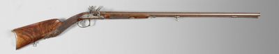 un vieux fusil avec une poignée en bois sur fond blanc