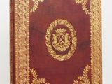 un vieux livre rouge avec des motifs dorés sur la couverture