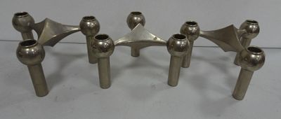 three silver metal candles are sitting on a white surface
