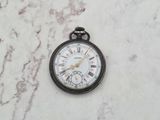a small pocket watch sitting on a marble surface