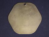a brass plate with a small hole in the middle