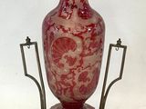 un vase posé sur un support sur une surface blanche