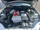 un moteur de voiture dont le capot est ouvert, garé dans la rue