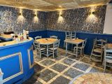 des tables et des chaises dans un restaurant aux murs bleus et au sol en marbre