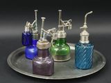 five different colored glass bottles sitting on a silver tray
