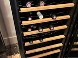 a wine cooler that has many bottles of wine in it