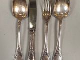 five spoons and a knife sitting on a table